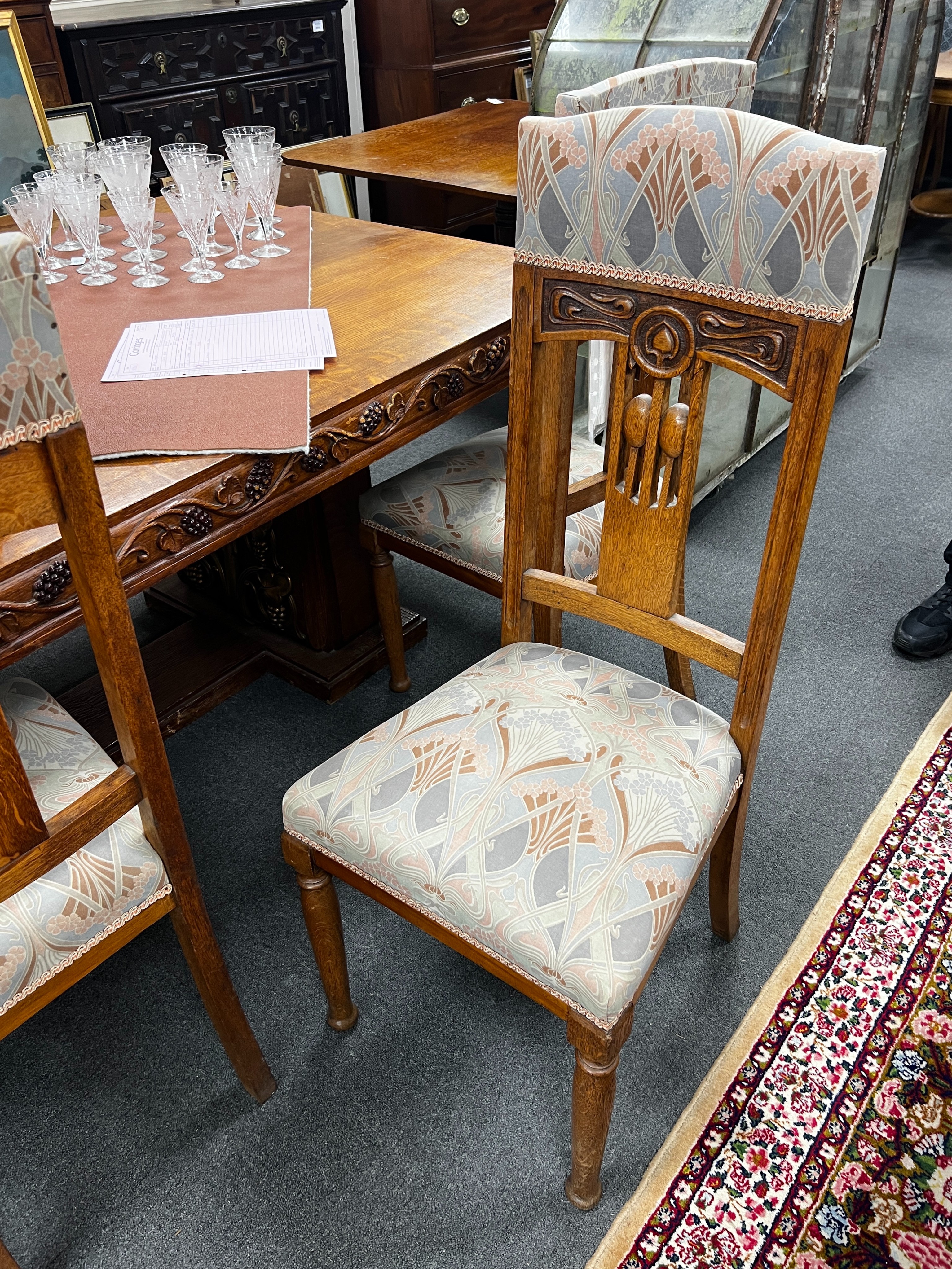 A set of Art Nouveau carved oak dining chairs, one with arms with original Liberty receipt